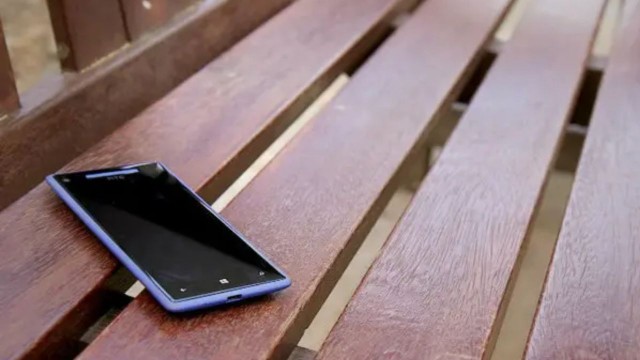 Persona sosteniendo un celular con un símbolo de candado y un escudo de seguridad digital.